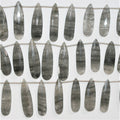 Perles en quartz tourmaliné St de taille graduée, en forme de goutte, à facettes, de 32 x 11 à 42 x 12 mm. Longueur approximative du brin : 20 cm.