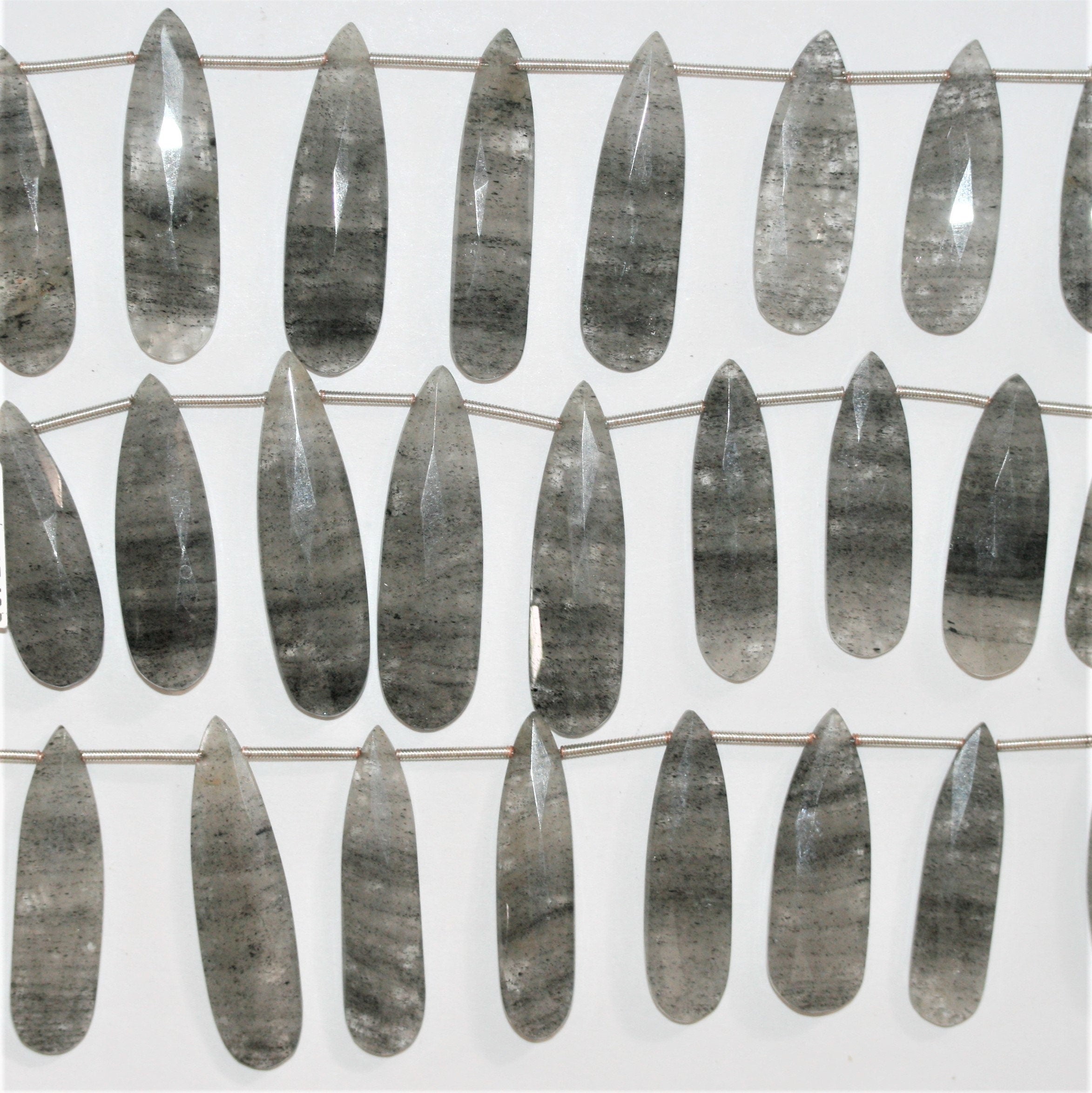 Perles en quartz tourmaliné St de taille graduée, en forme de goutte, à facettes, de 32 x 11 à 42 x 12 mm. Longueur approximative du brin : 20 cm.