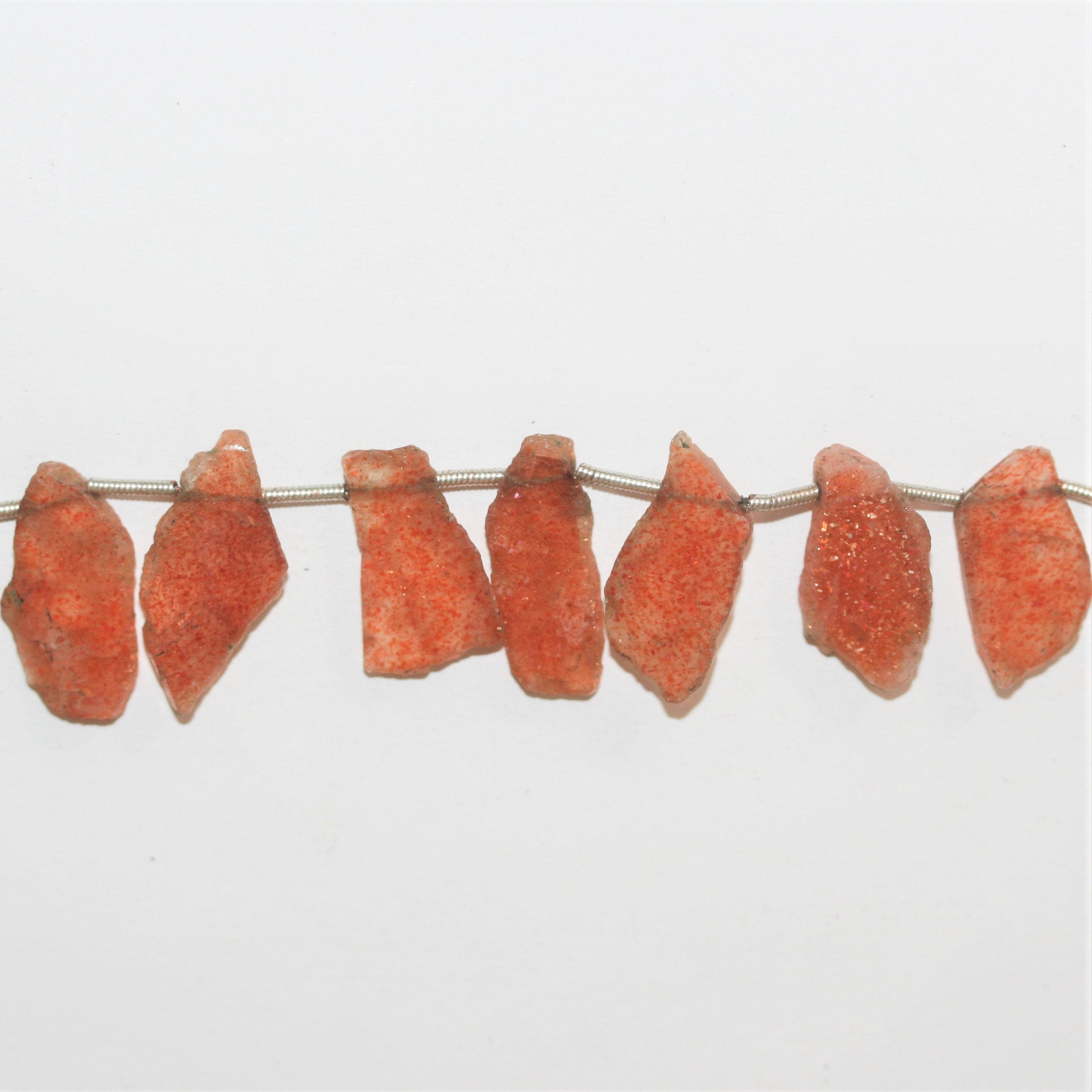 Perles plates irrégulières en pierre de soleil St 8" 18x11mm. Environ - Longueur du brin 21cm.