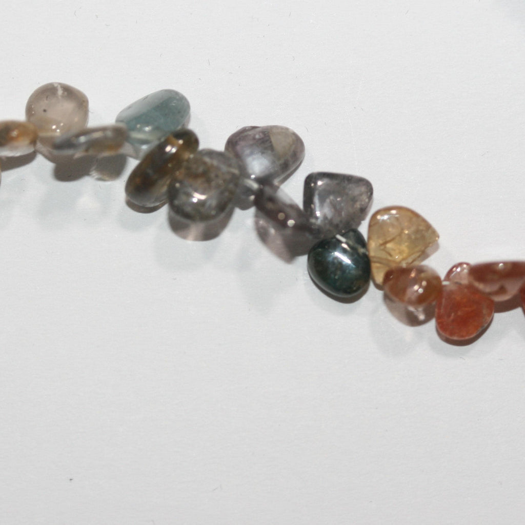 Perles de spinelle multicolores en forme de pépites, lisses, plates et irrégulières, de 6 à 8 mm environ. Fil de 40 cm. Réf. 14992