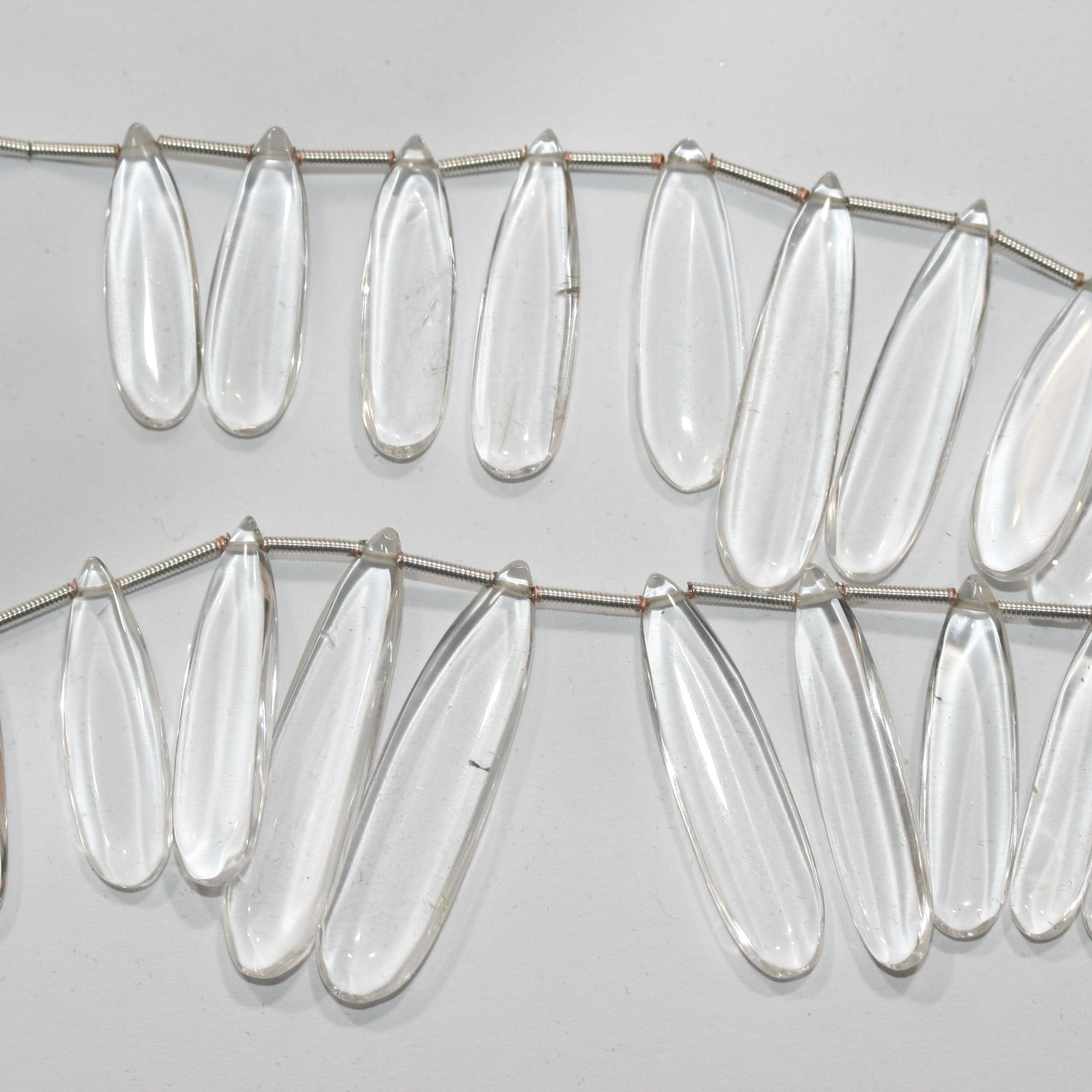 Perles plates lisses en cristal de roche de 20 cm (8 pouces), 37 x 9,5 à 22,7 x 8 mm, longueur 20 cm. Réf. 14995