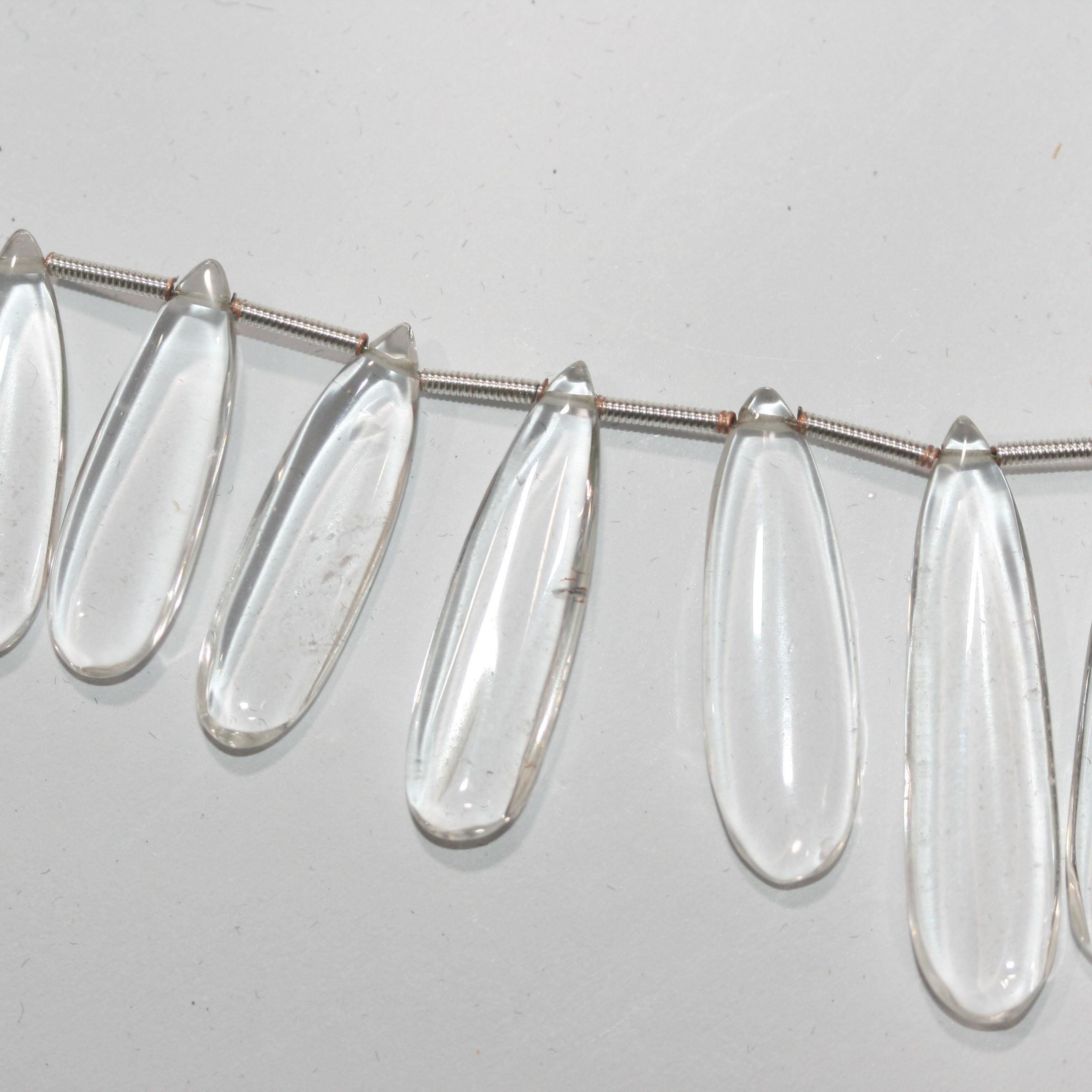 Perles plates lisses en cristal de roche de 20 cm (8 pouces), 37 x 9,5 à 22,7 x 8 mm, longueur 20 cm. Réf. 14995